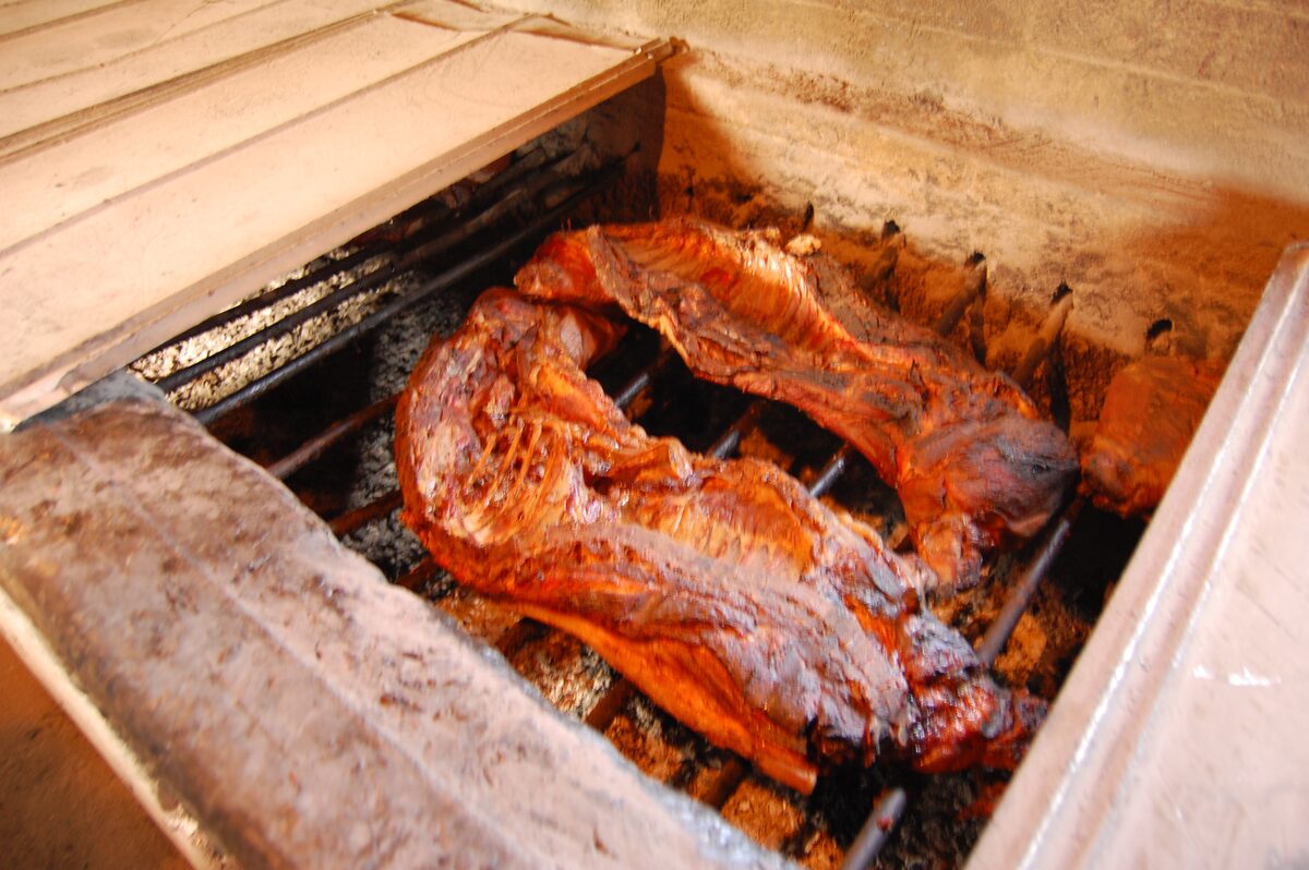 A whole hog roasting over coals in an open pit at Wilbur's Barbecue in Goldsboro, North Carolina