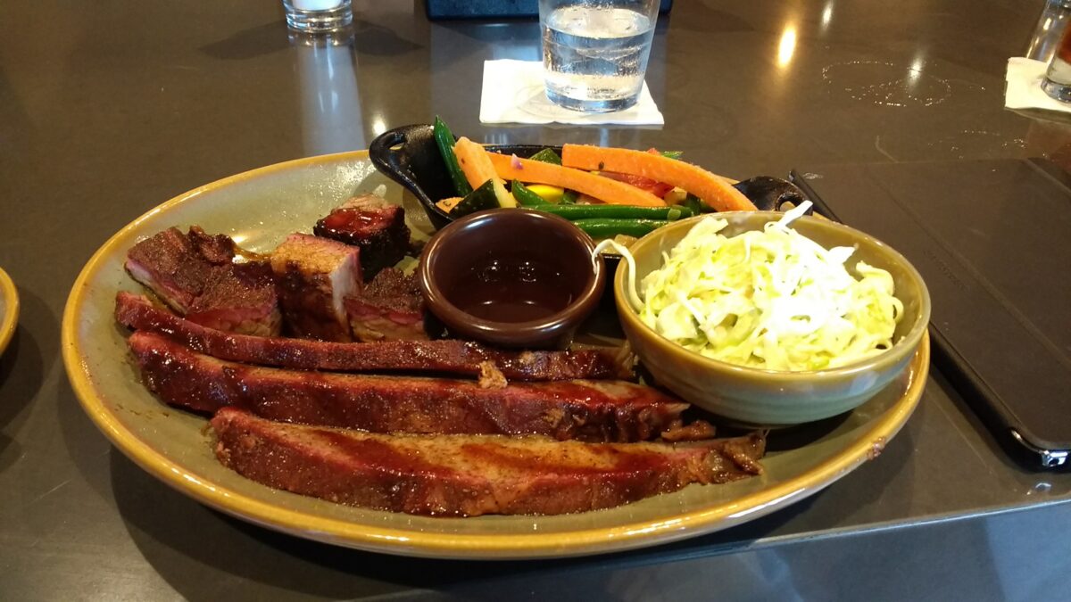 A barbecue plate of sliced brisket with coleslaw and a cup of sauce at Q39 in Kansas City