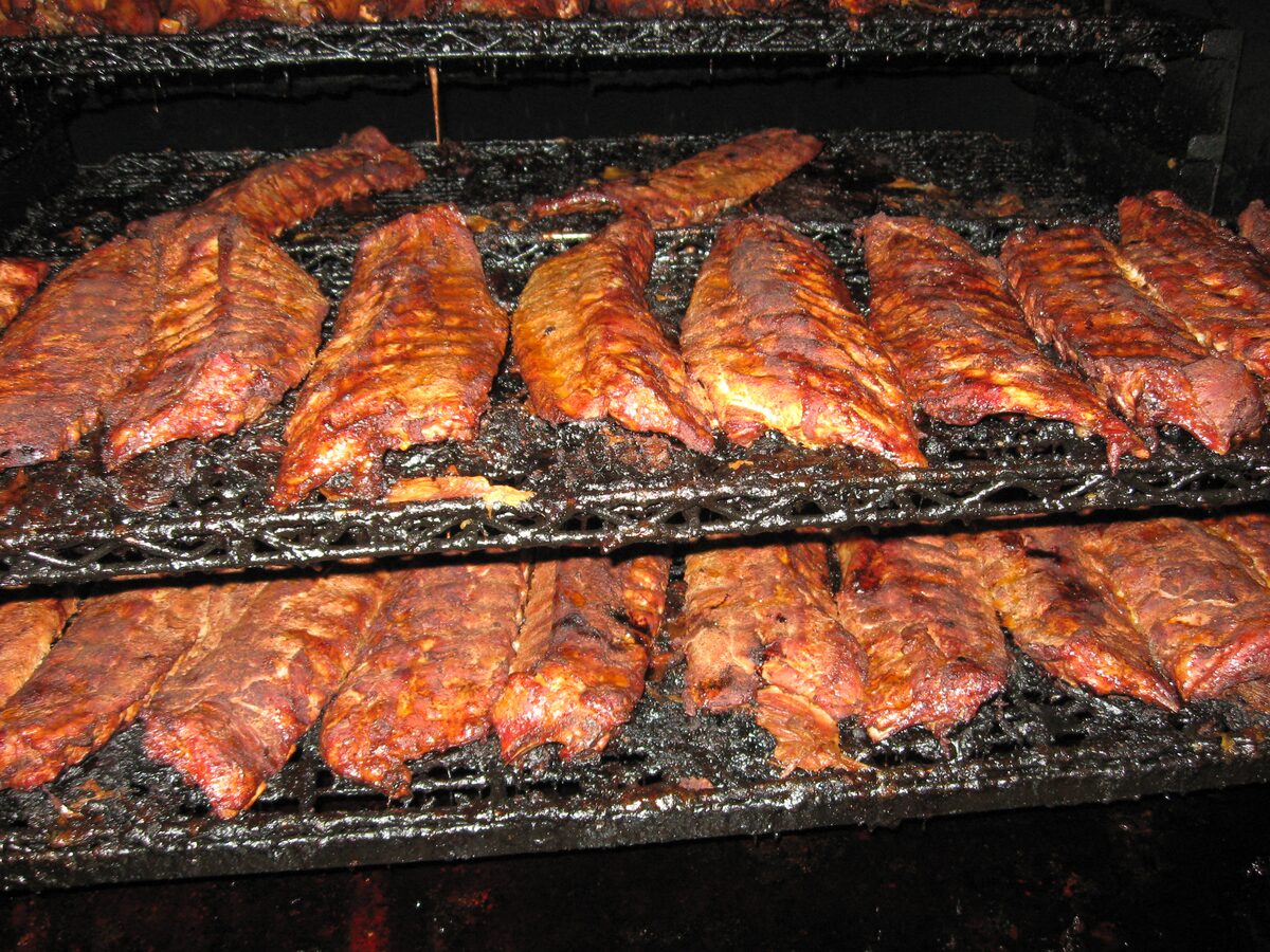 Two shelves of dark, spice-crusted pork ribs in the smoker at Central BBQ in Memphis