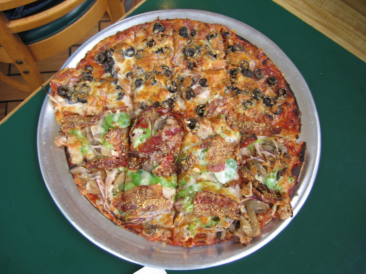 An Imo's St. Louis-style pizza, thin crust cut into squares, on a metal pan