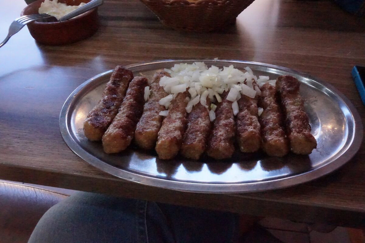 A plate of cevapcici with chopped onion on a table in Novi Pazar, Serbia