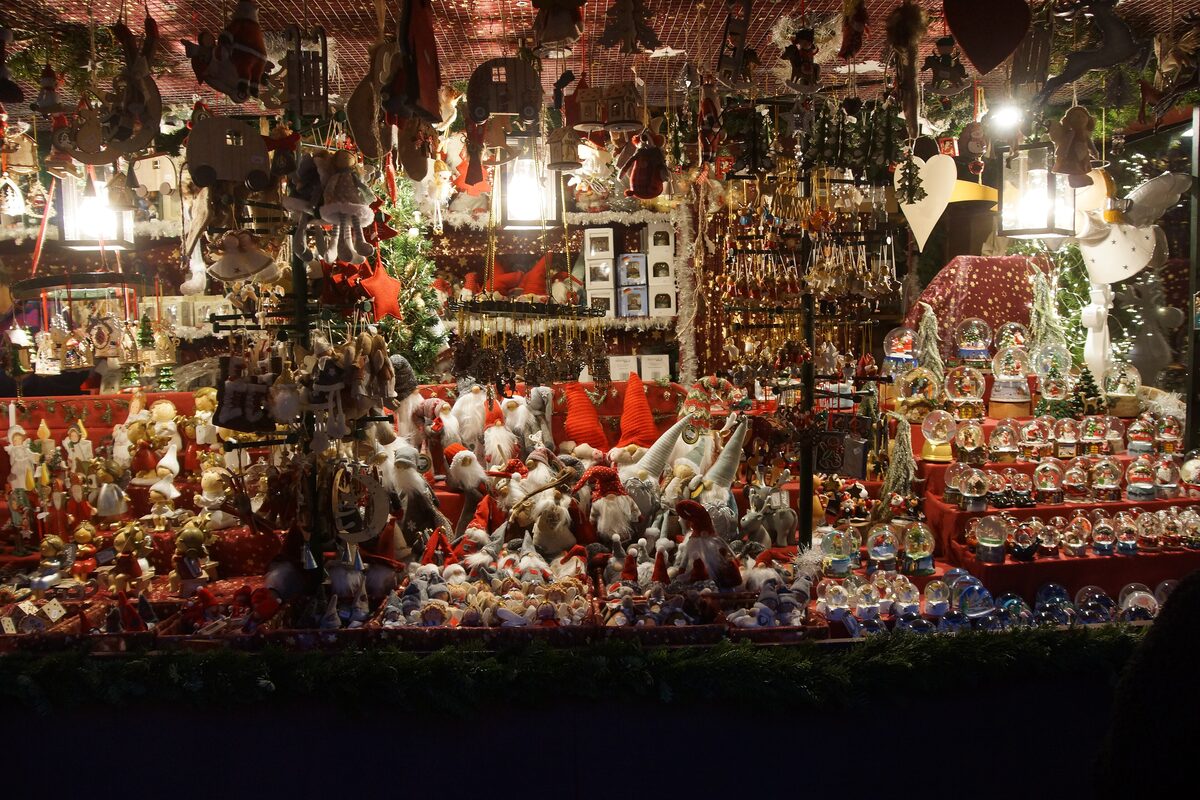 A stall at the Nuremberg Christkindlesmarkt with gingerbread hearts and lanterns under a lit roof
