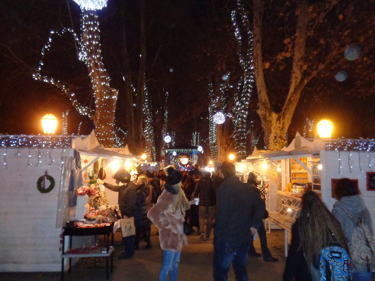 White market huts and lit trees on Zrinjevac park during Advent in Zagreb