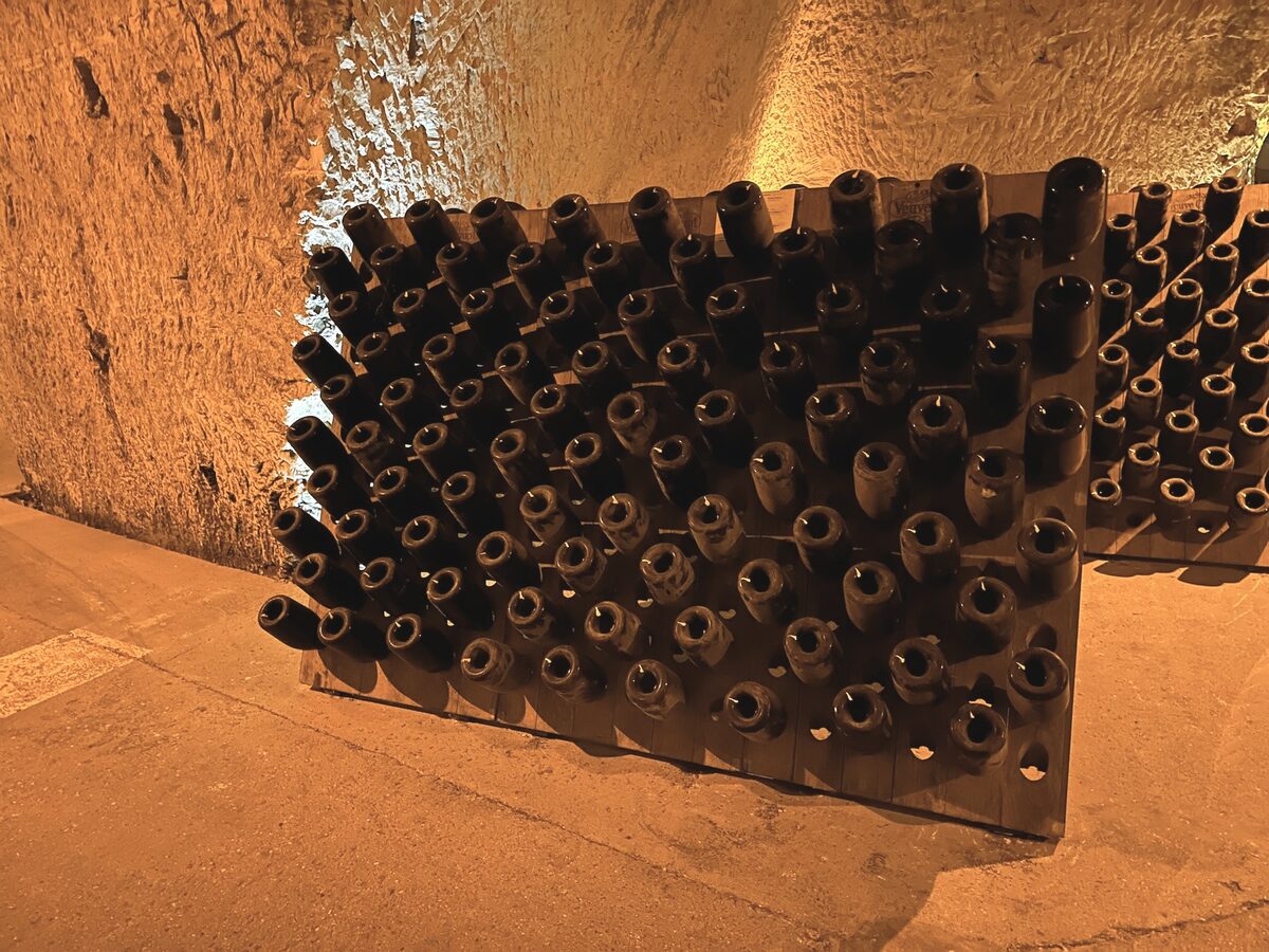Bottles resting neck down on a riddling rack in a chalk cellar in Reims