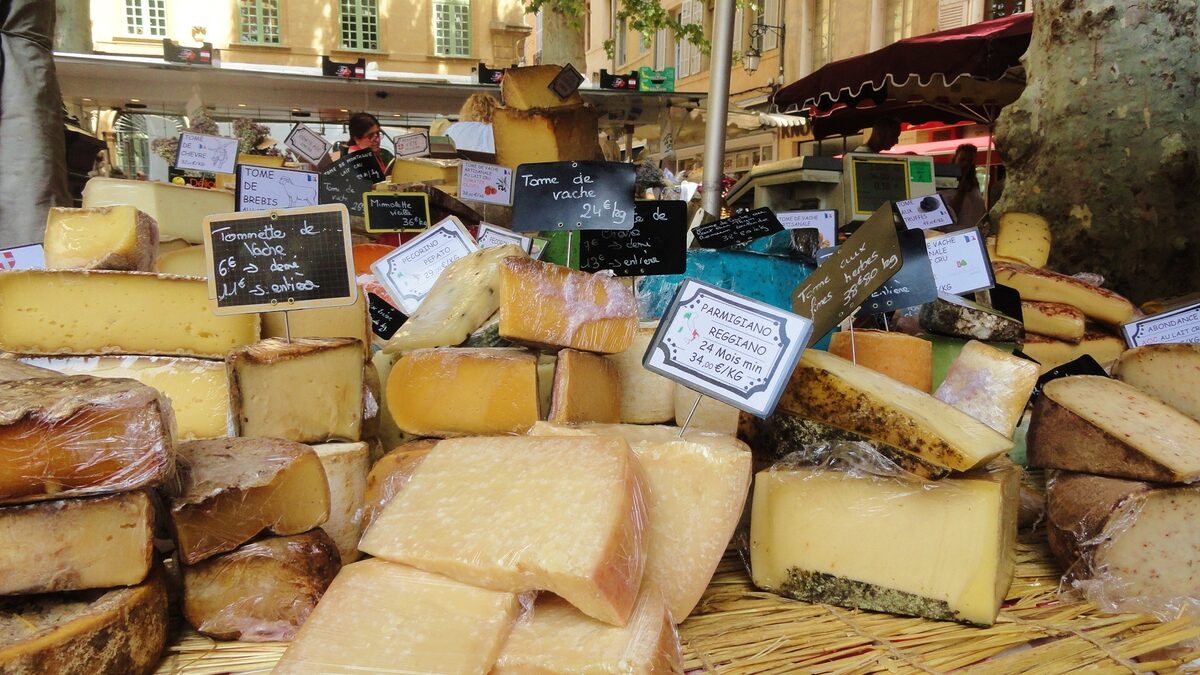 Wheels and wedges of French cheese on a market stall