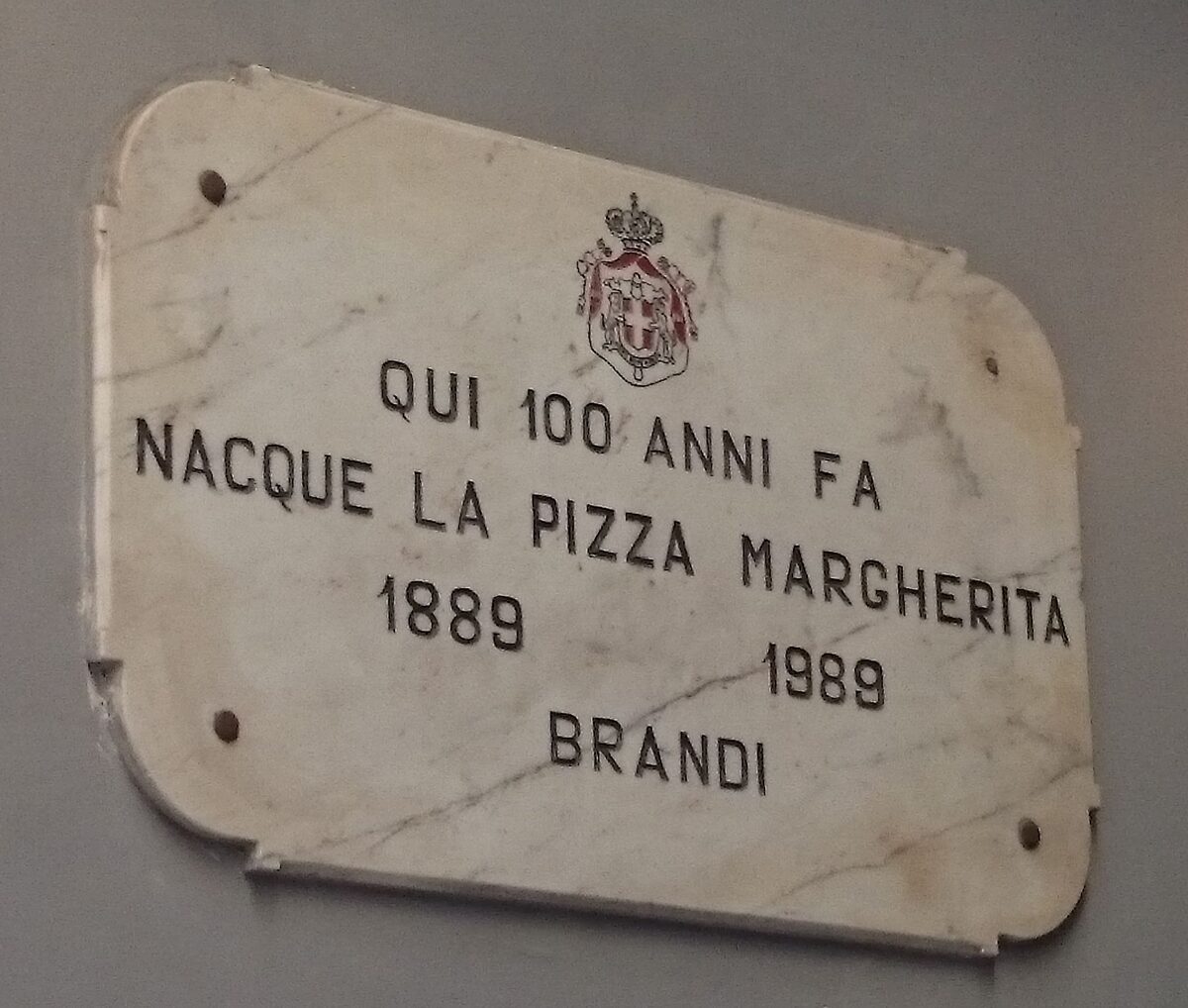 A marble plaque at Pizzeria Brandi in Naples saying the Margherita pizza was born there in 1889