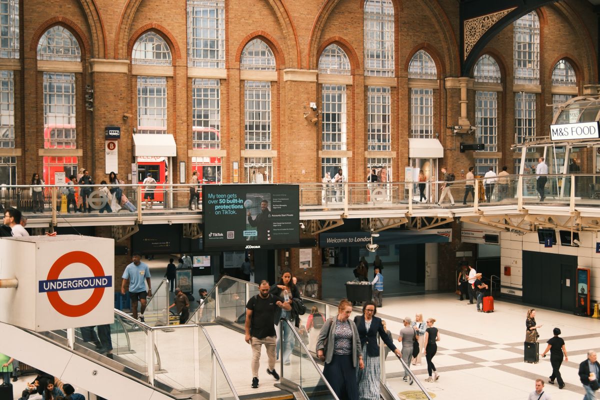 The main concourse of Liverpool Street station, with its tall arched windows, escalators and a London Underground roundel sign