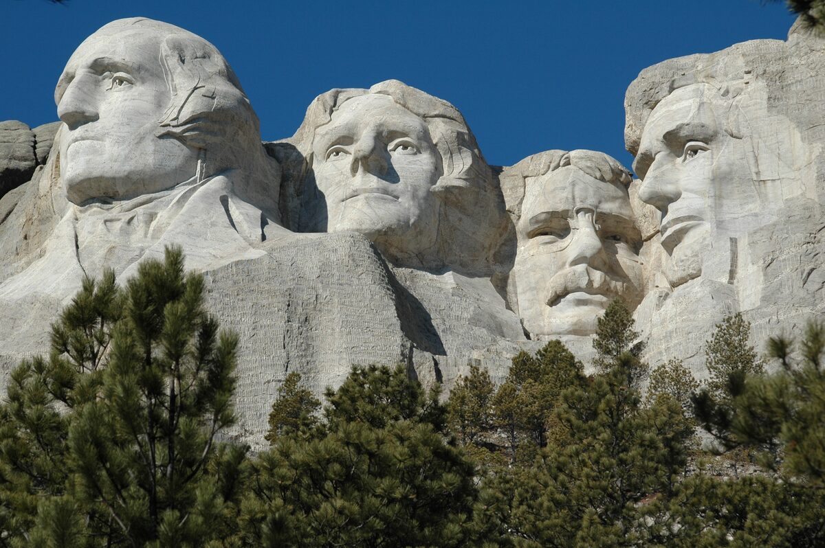 Mount Rushmore seen from the Presidential Trail, with ponderosa pines below the carved faces