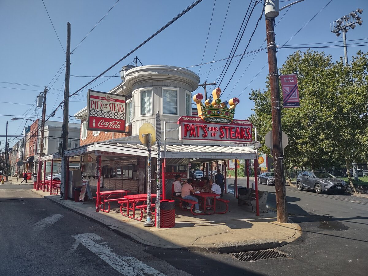 Pat's King of Steaks, the corner stand with its crown sign and red picnic tables in South Philadelphia