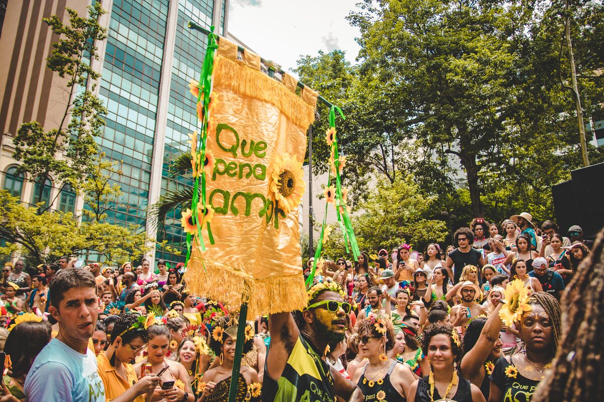 Crowd around a bloco banner at a street carnival party in Rio