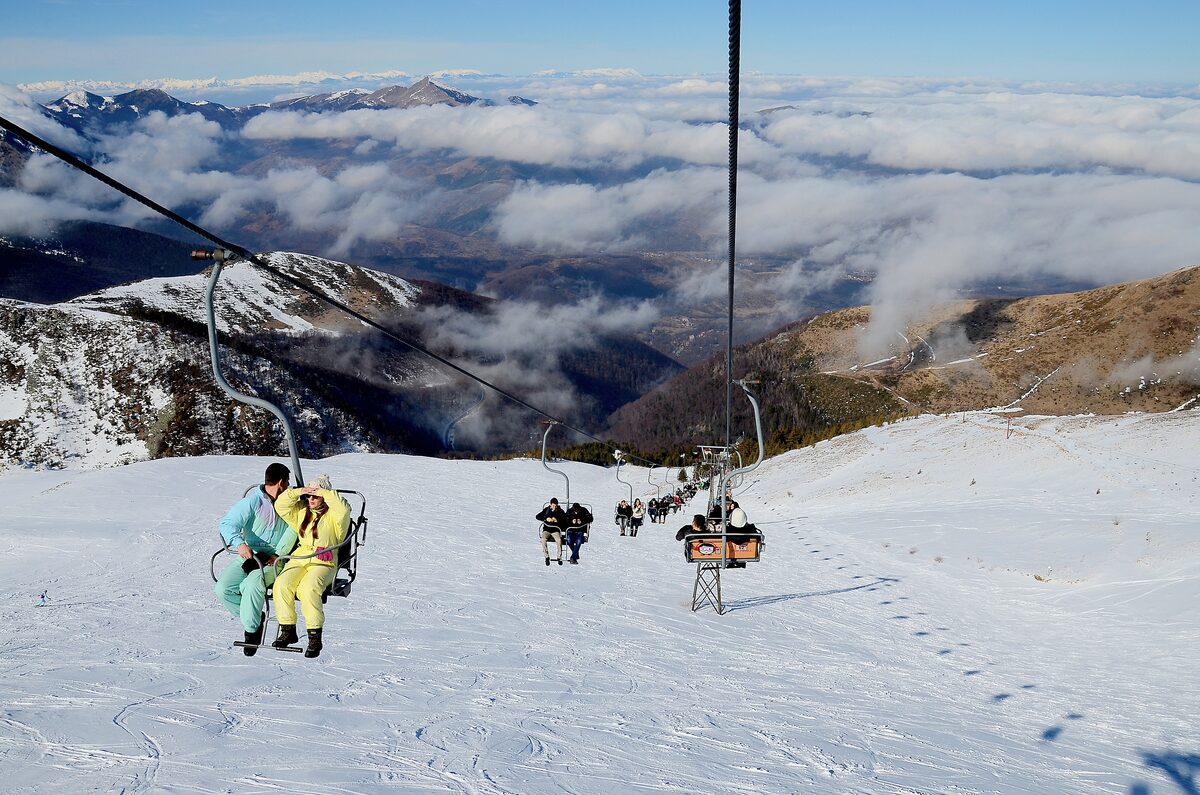 Two skiers on a chairlift above the snowy slopes of Brezovica, on ล ar planina in Kosovo and Metohija, Serbia