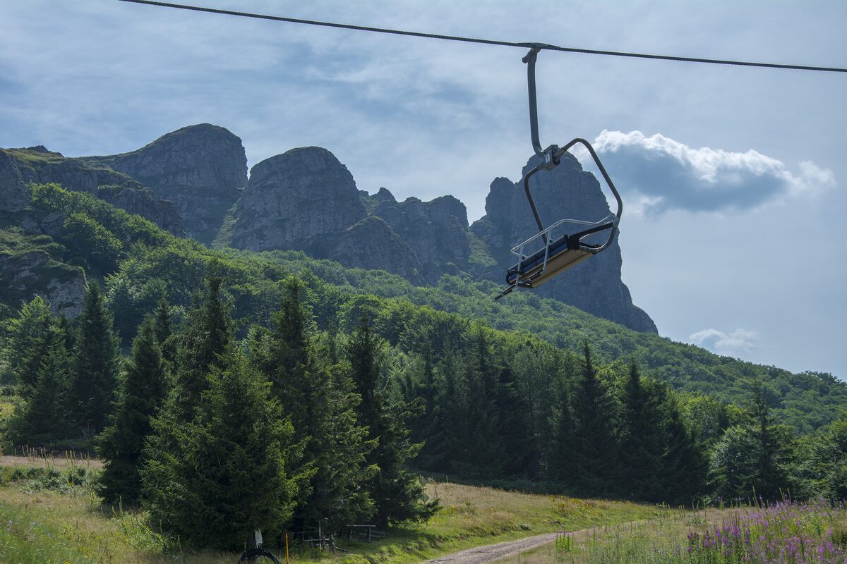 A chairlift in summer below the rock towers of Babin Zub, Stara Planina