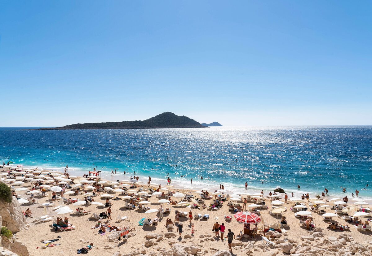 Kaputas beach near Kas on the Turkish coast, umbrellas on the sand and a small island out in the blue sea