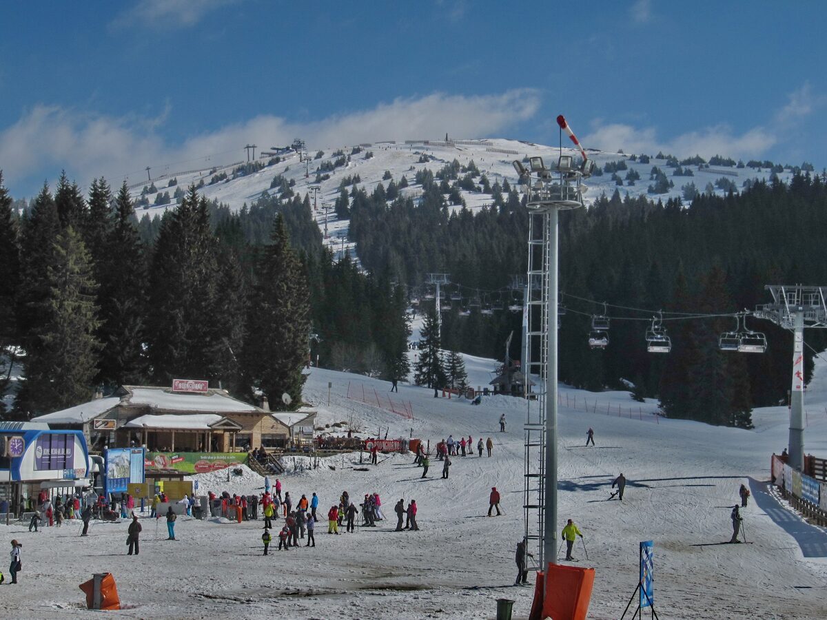 Skiers crowding the base area at the Brzeće lift station on Kopaonik, with snowy slopes above