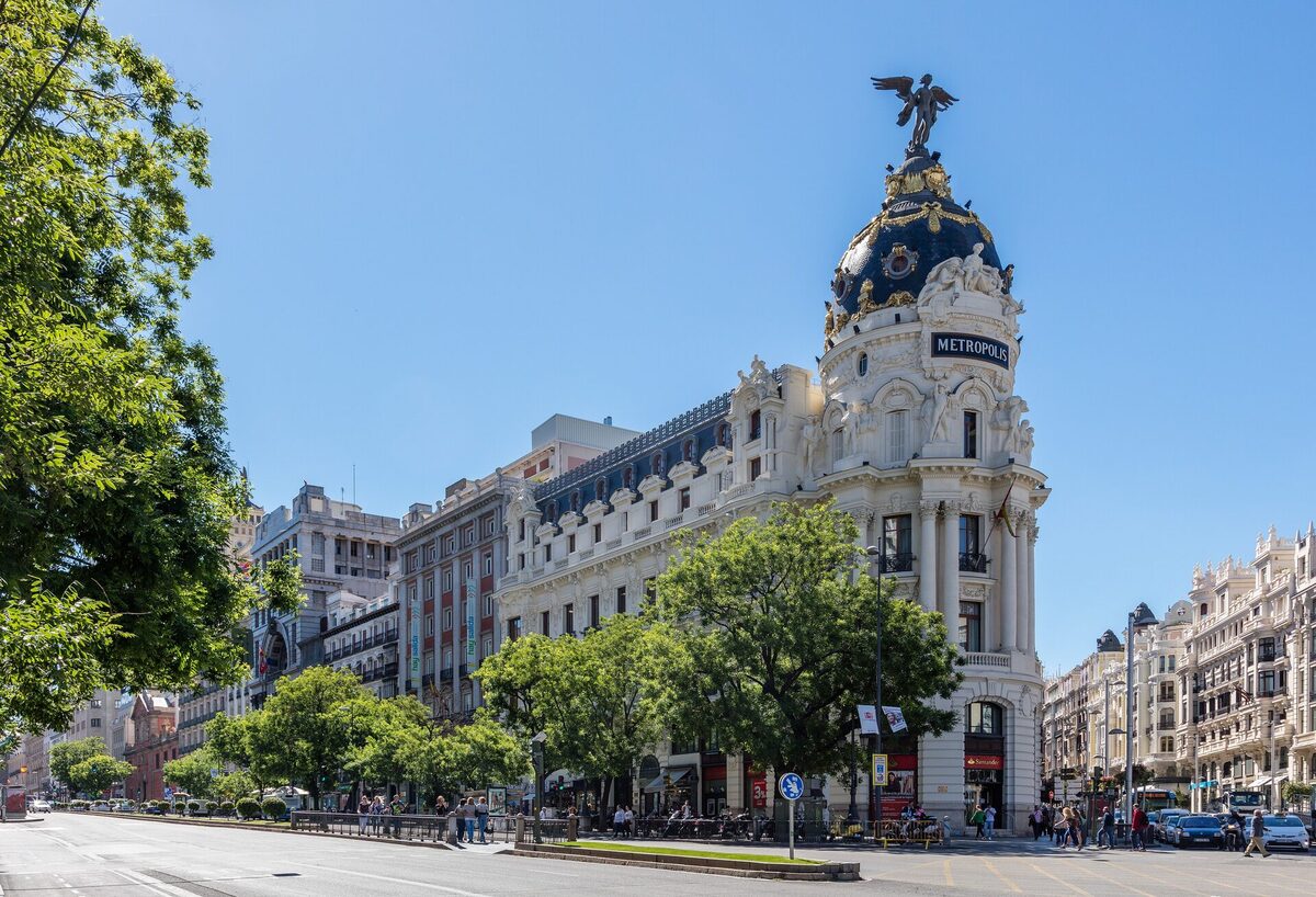 The Metrópolis building on Gran Vía in Madrid, with its slate dome and winged statue under a blue sky