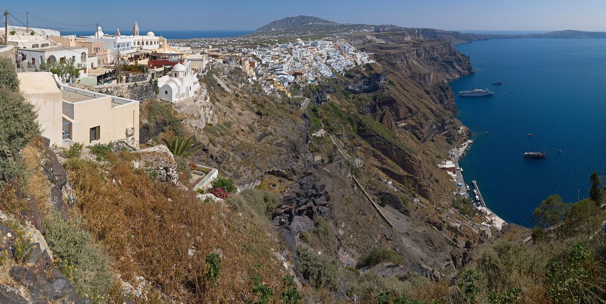 The cliff of the Santorini caldera with the white town of Fira along the rim and the sea beyond