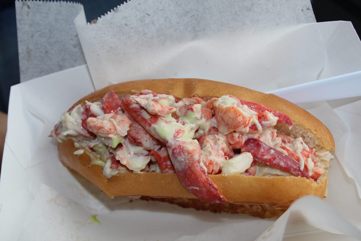 A lobster roll with chunks of lobster meat in a toasted bun