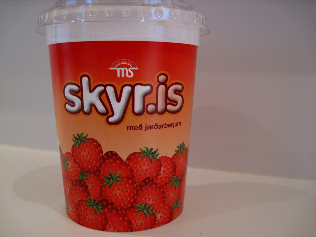 A plastic cup of skyr.is strawberry skyr, red with a picture of strawberries, as sold in Icelandic supermarkets