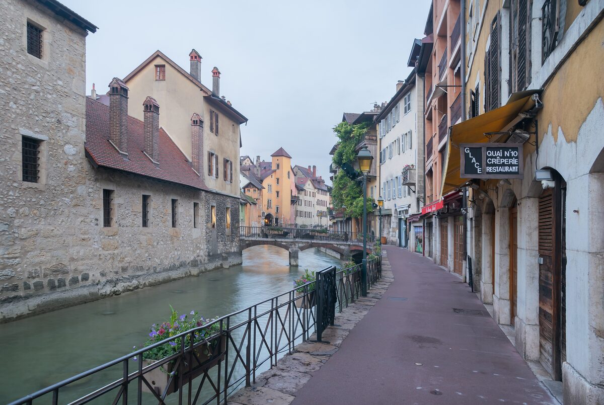 The Thiou canal in the old town, with an iron railing along the quay and tall old houses lining the street