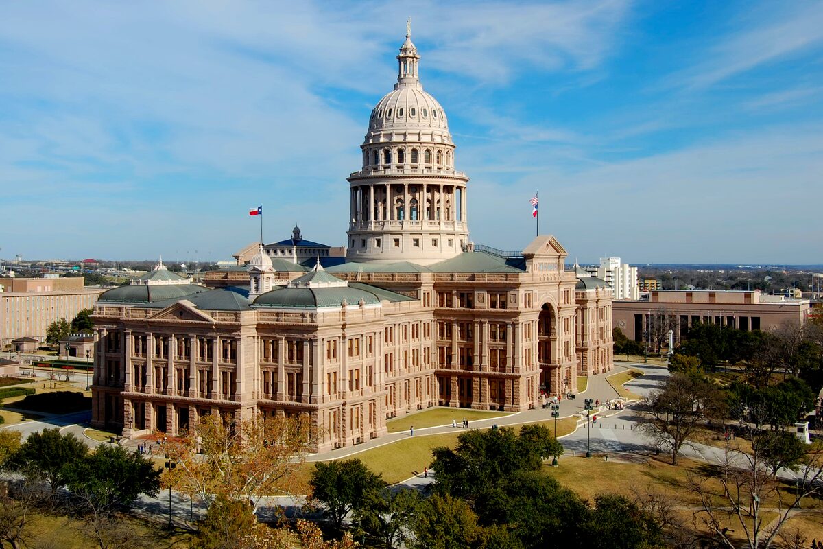 The pink granite Texas State Capitol with its dome, seen from above across the grounds