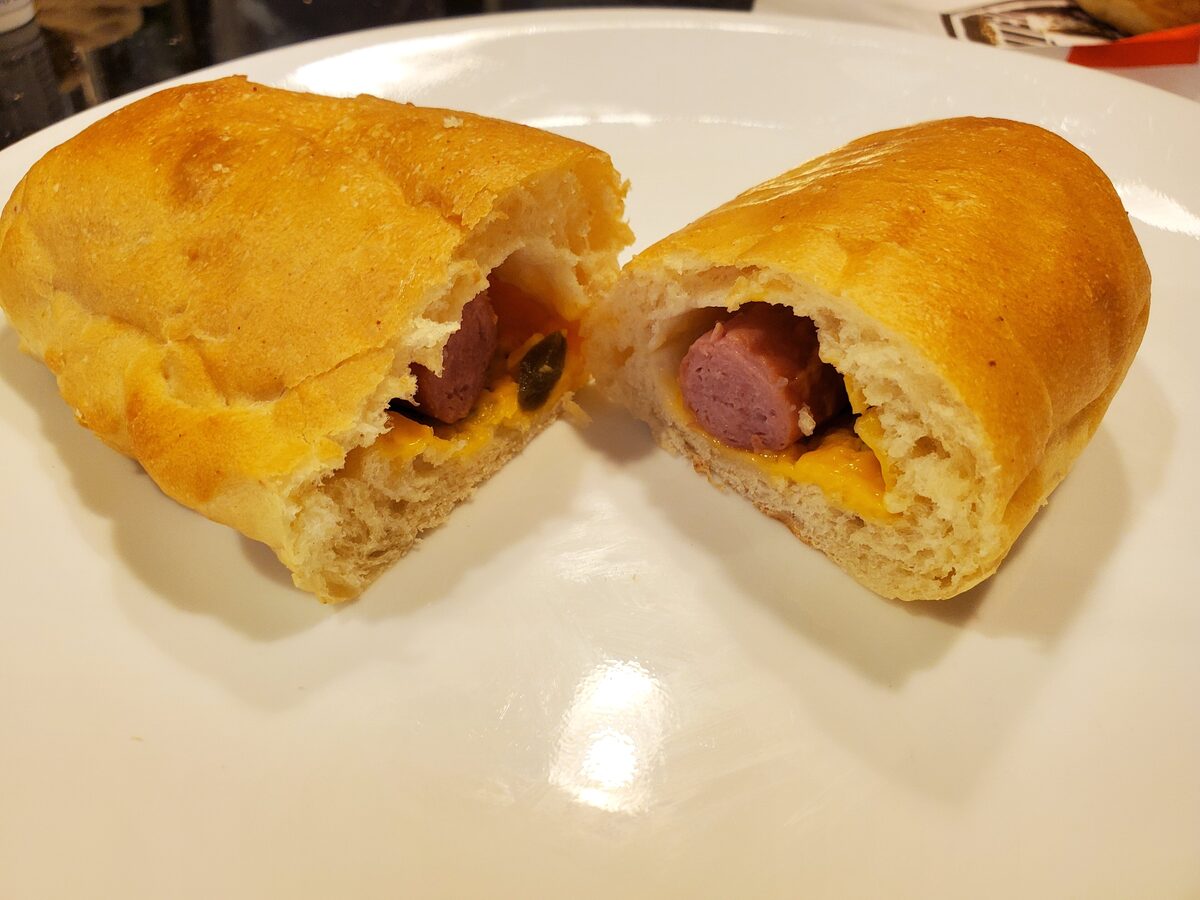 A Texas kolache cut open to show a sausage, cheese and jalapeno filling