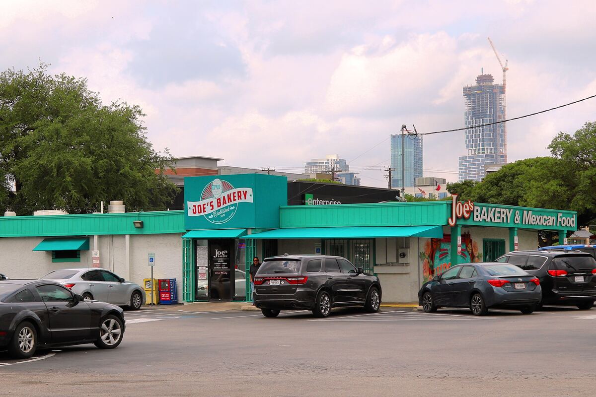 The teal front of Joe's Bakery & Coffee Shop on East 7th Street with the downtown skyline behind