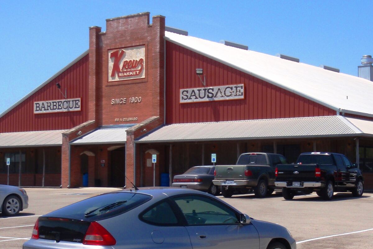 The red barn-style front of Kreuz Market in Lockhart with its Barbecue and Sausage signs