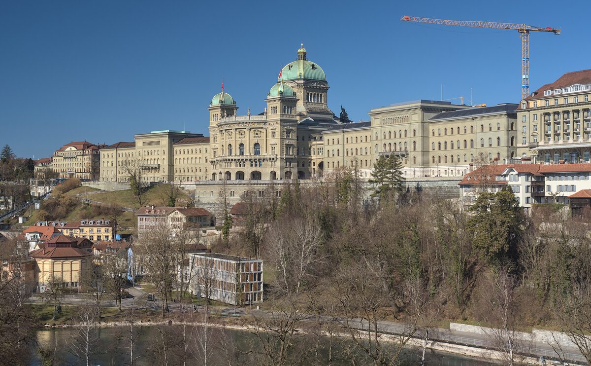 The Federal Palace across bare winter trees, its wings and central dome rising above the river side