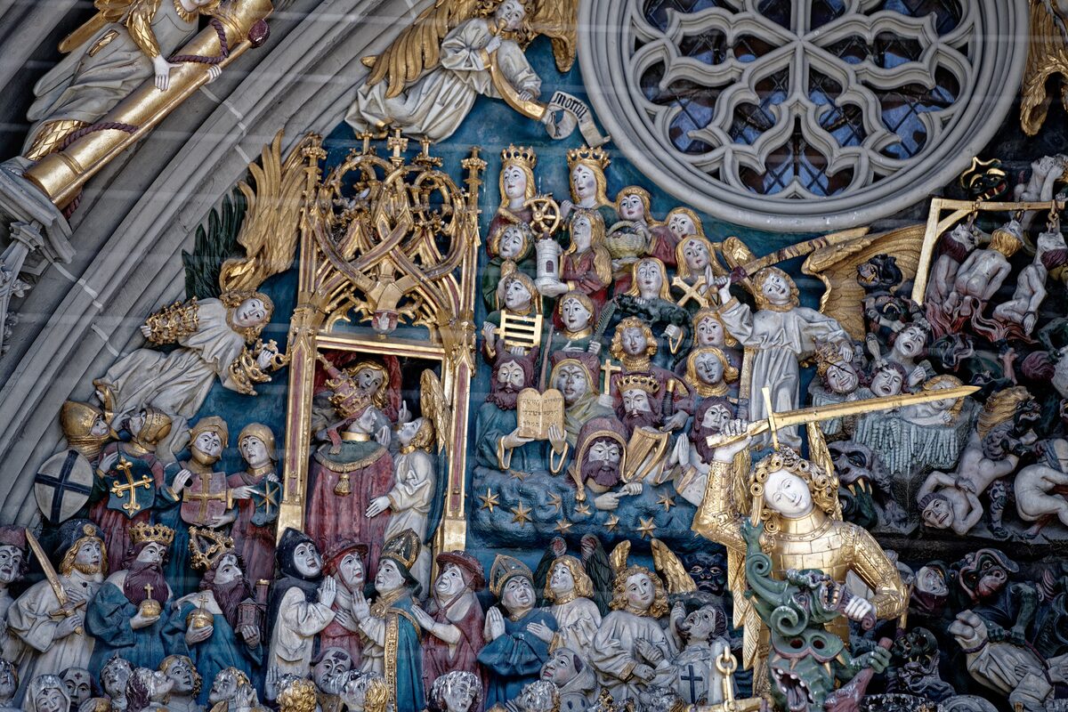 Carved figures of the Last Judgment on the Minster portal, crowded together and painted in gold and colour