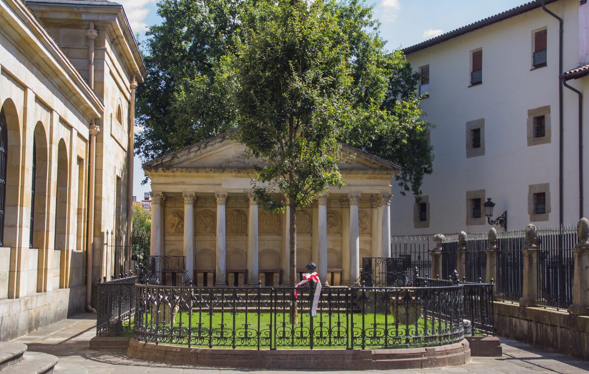 The young oak of Gernika in front of its small columned temple, behind an iron railing