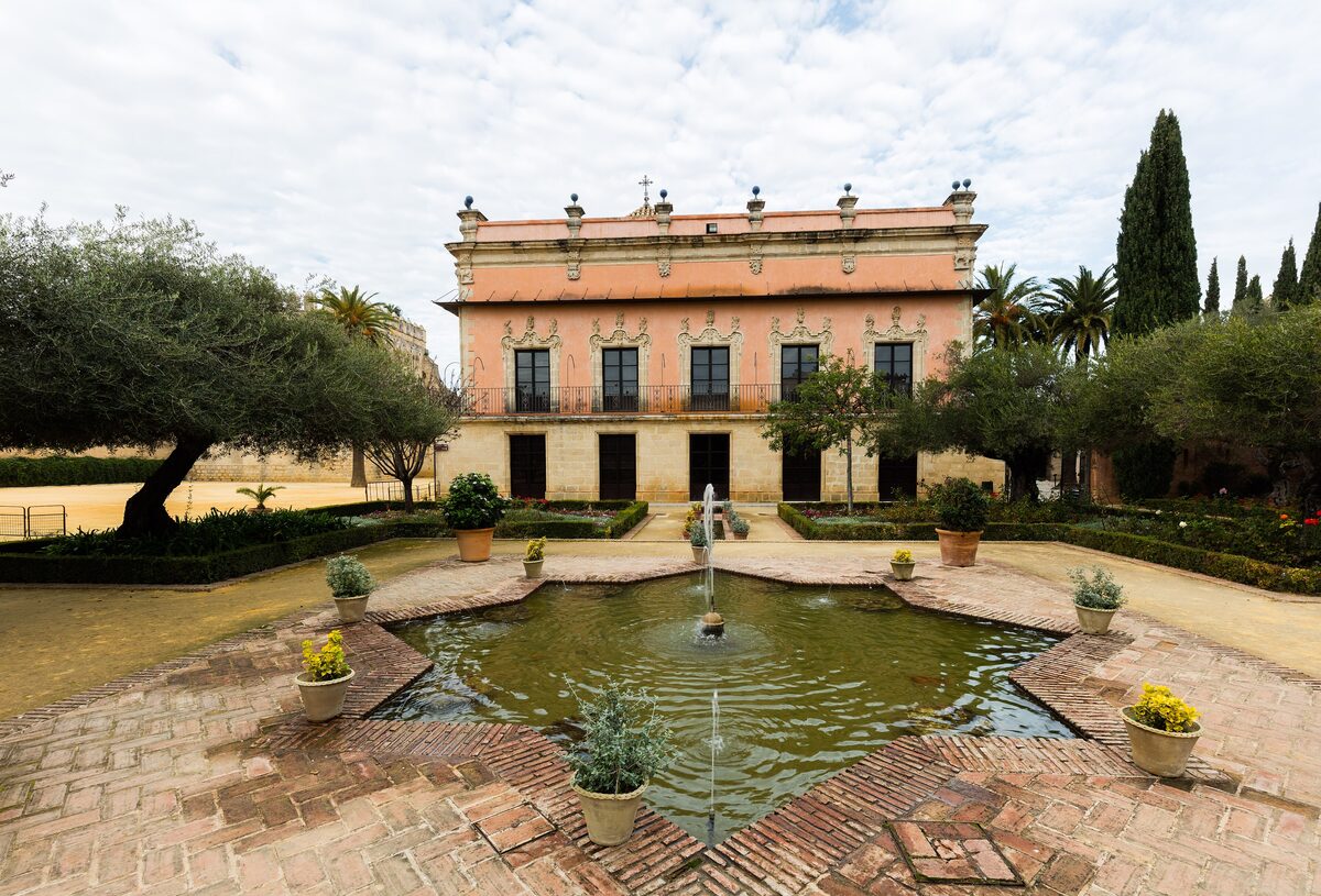 The Palacio de Villavicencio above a star-shaped pool in the Alcázar gardens