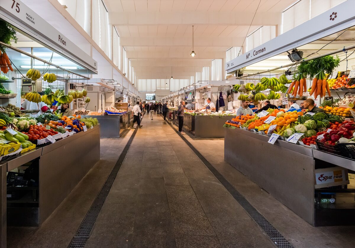 The long aisle of the Mercado Central, with produce stalls under a white roof