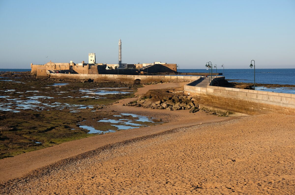 The causeway to Castillo de San Sebastián over sand and rock at low tide