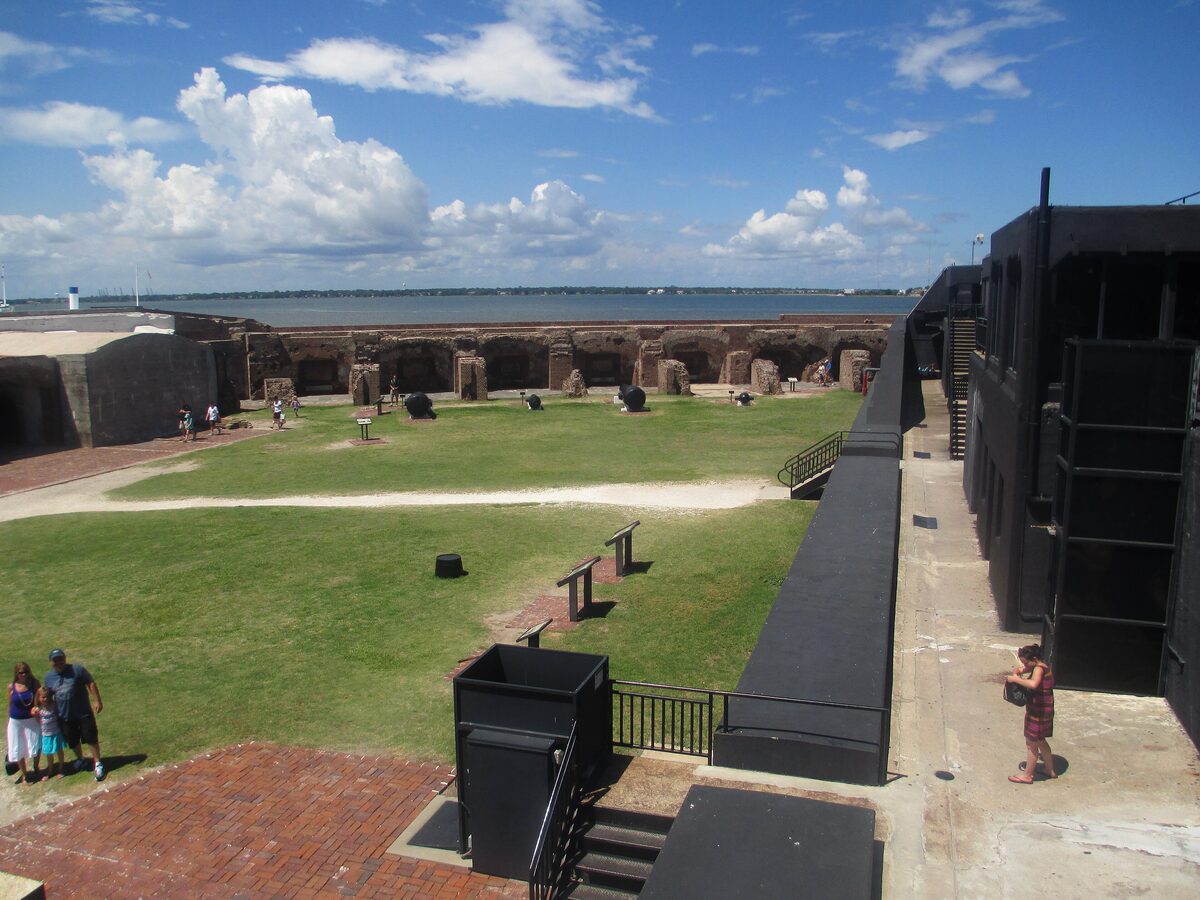Parade ground and brick casemates inside Fort Sumter under blue sky