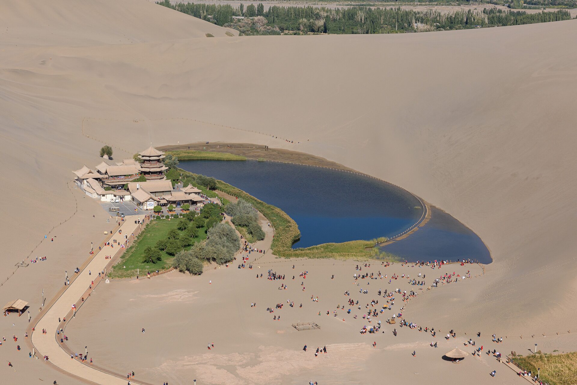 Aerial view of Crescent Lake in a hollow between the sand dunes of Mingsha Shan, with the pagoda-roofed pavilions on the shore