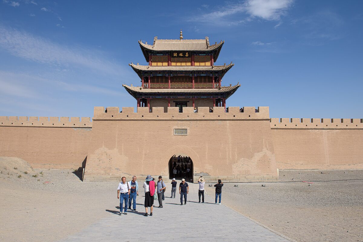 The three-storey gate tower and wall of Jiayuguan Fort under a blue sky