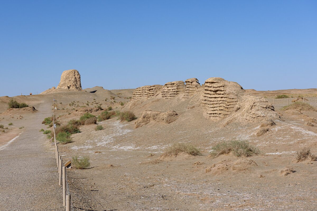 Eroded layers of the rammed-earth Han wall and a tower stump on gravel desert west of Yumen Pass