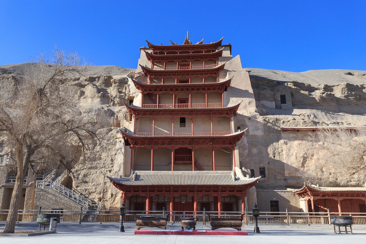 The red nine-storey wooden facade built against the cliff at the Mogao Caves, seen from outside