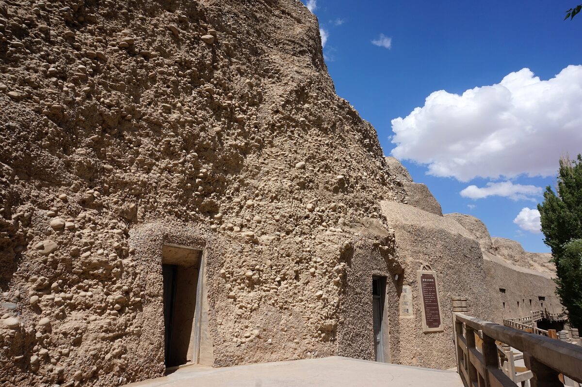 Cave doorways in the conglomerate cliff face at the Western Thousand Buddha Caves, seen from outside