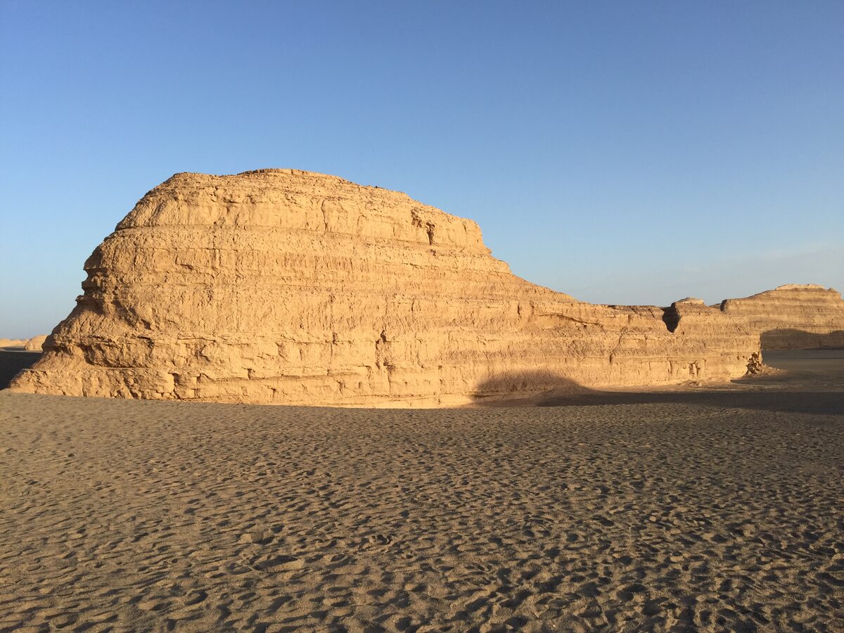 A wind-carved yardang ridge of layered sandstone in the Gobi, lit by low sun