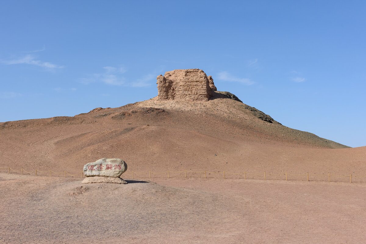 The ruined beacon tower on its mound at Yangguan, with a boundary stone in front
