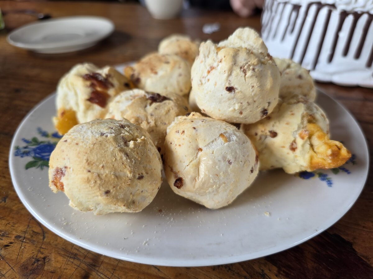 Chipa, round cheese and manioc rolls on a white plate on a wooden table