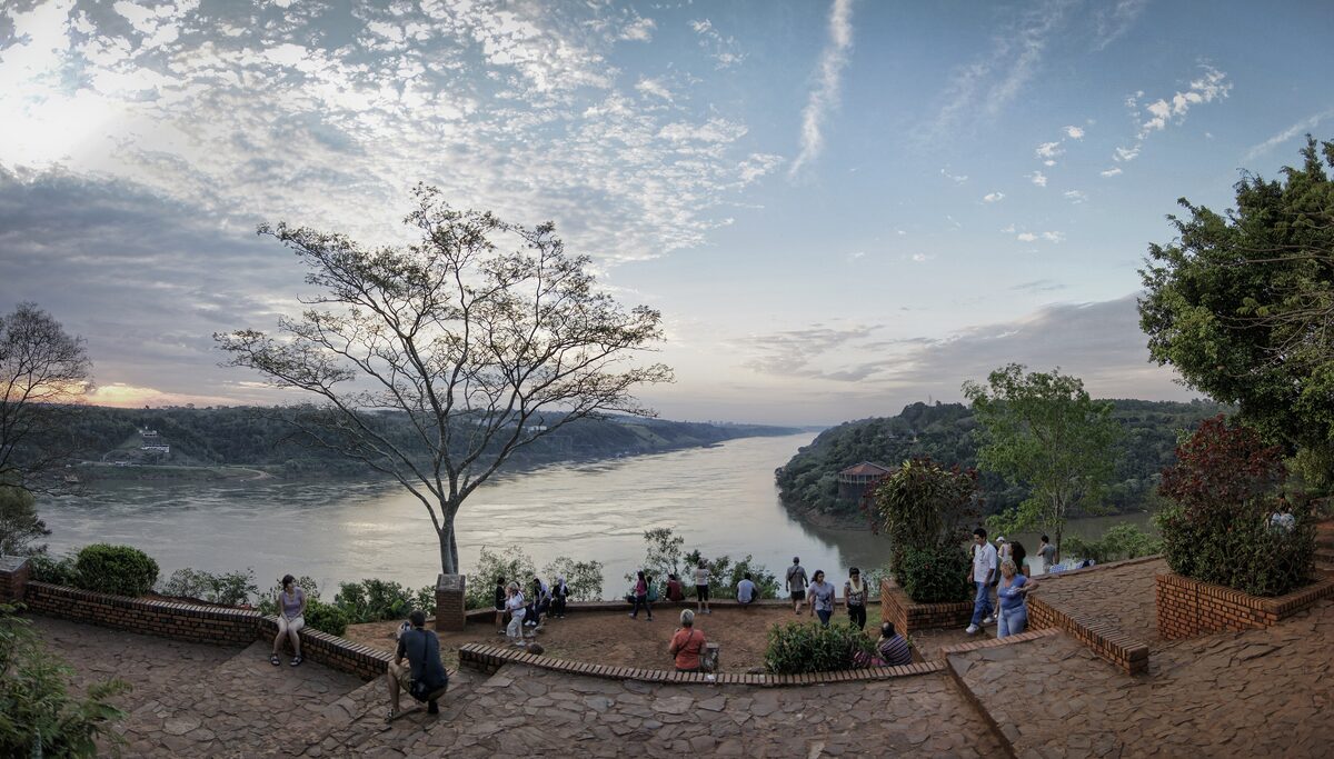The Triple Frontier viewpoint at Puerto Iguazú, with the rivers meeting below and visitors at the railing