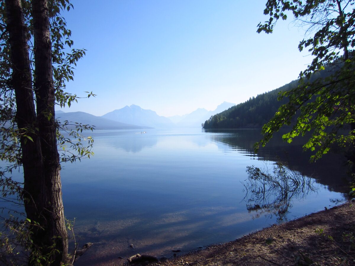 Lake McDonald shore near Apgar with distant mountains in morning haze