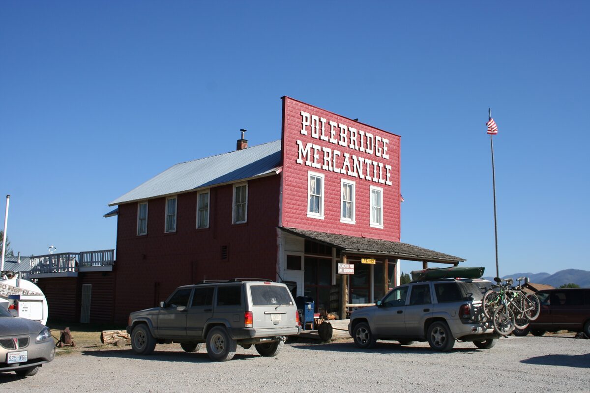 Red Polebridge Mercantile building with parked cars and bicycles