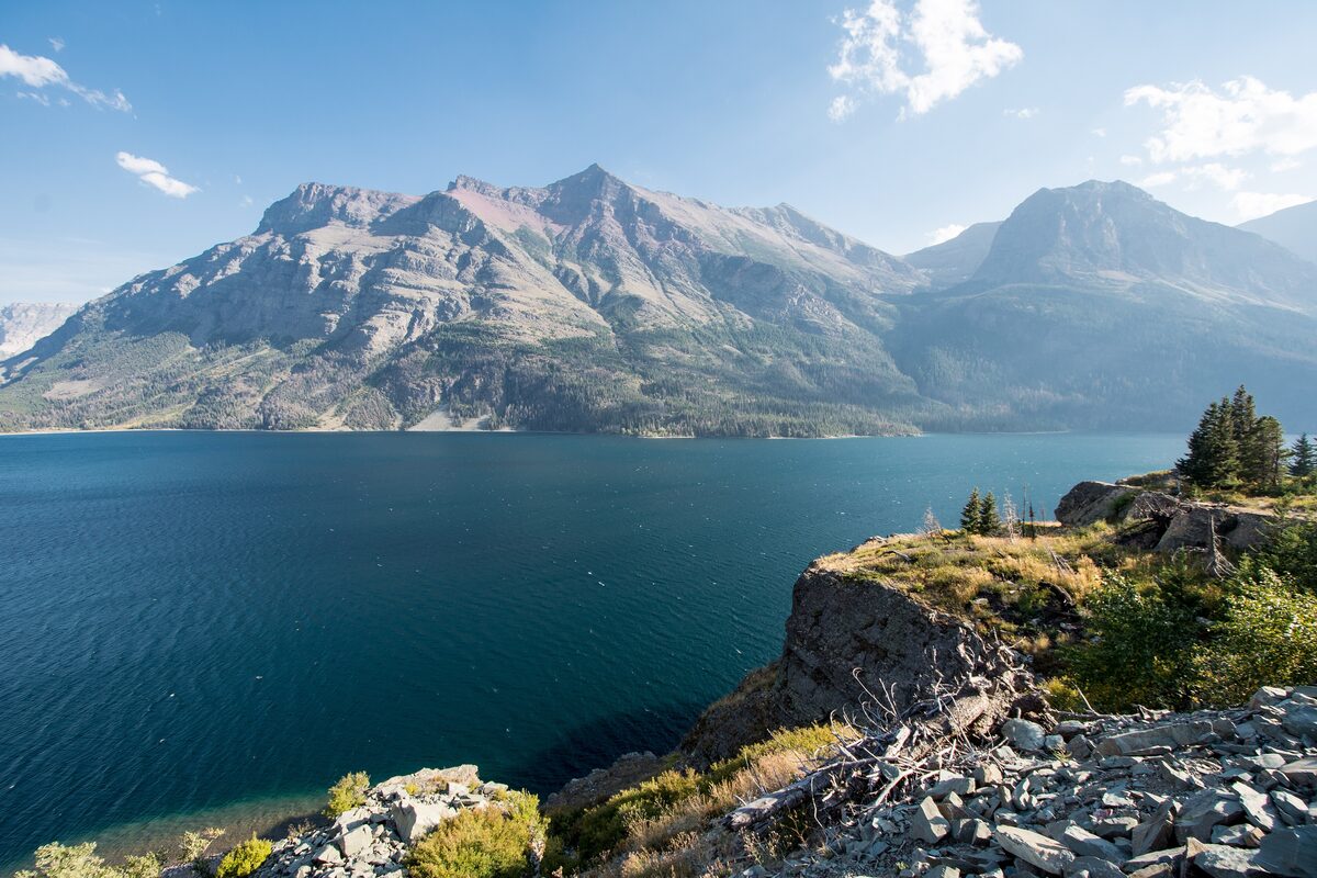 Deep blue St. Mary Lake below mountains on a clear day