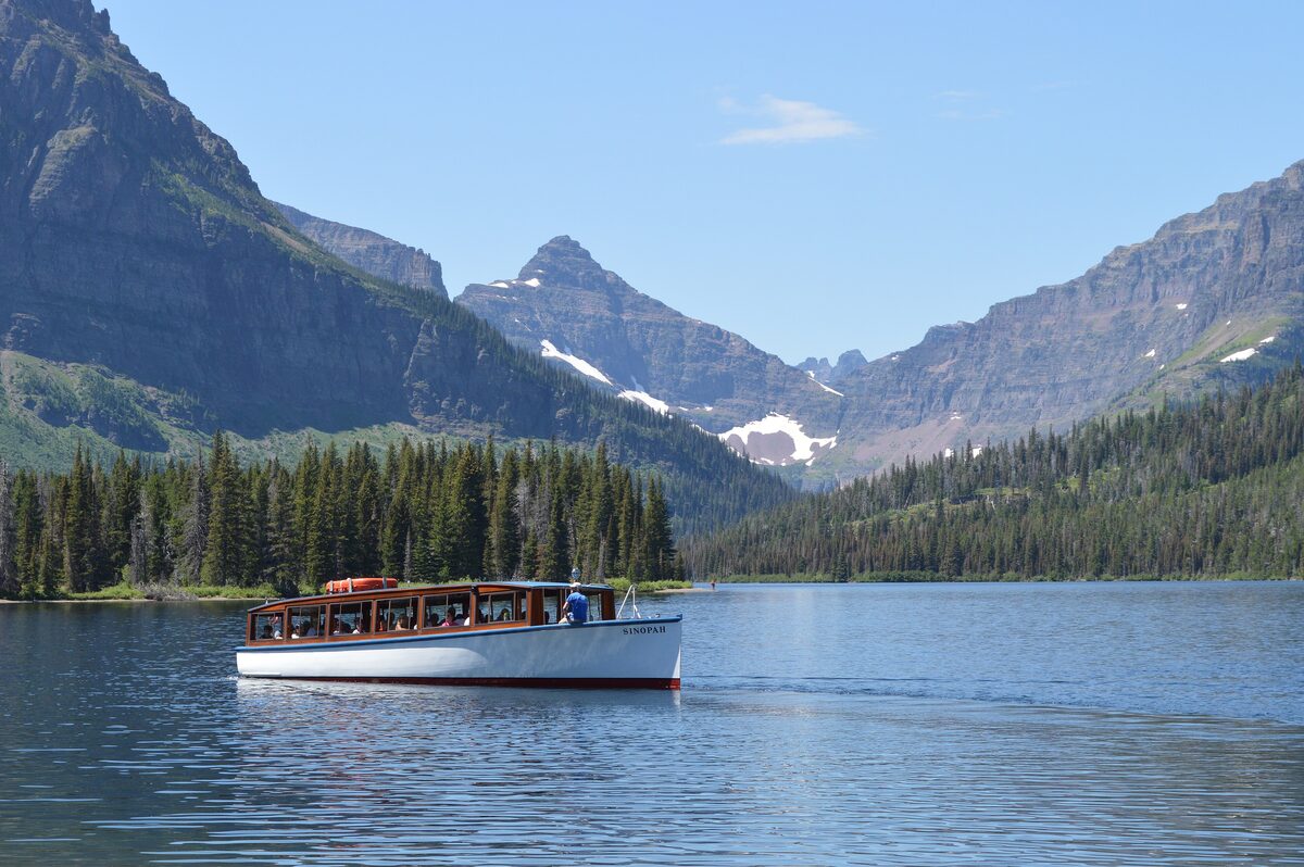 Tour boat crossing Two Medicine Lake below the peaks