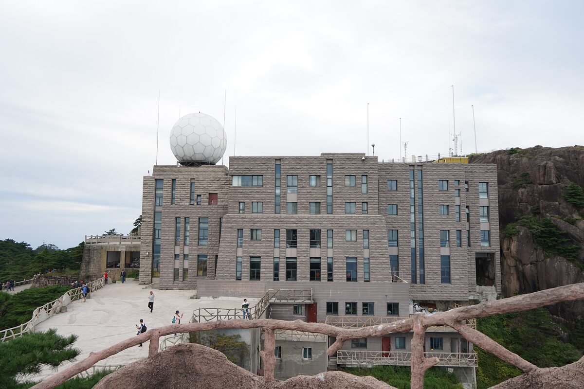 The weather station on Bright Summit, a stone building with a white radar dome, and visitors on the terrace