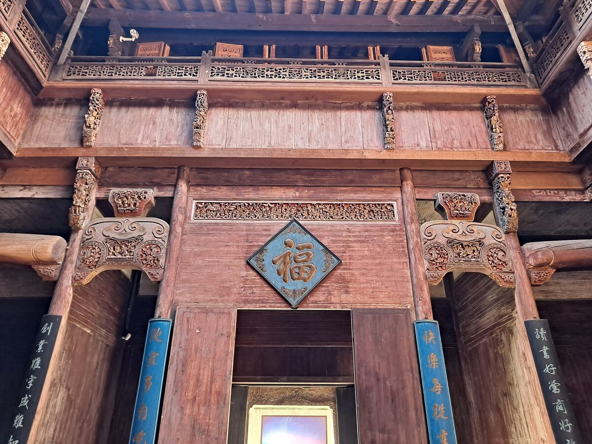 Carved and painted wooden beams and a gilded fu character inside Chengzhi Hall
