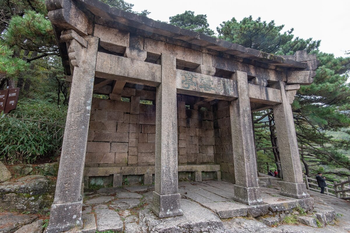 The stone Paiyun Pavilion among pines, a square granite shelter with a wide roof